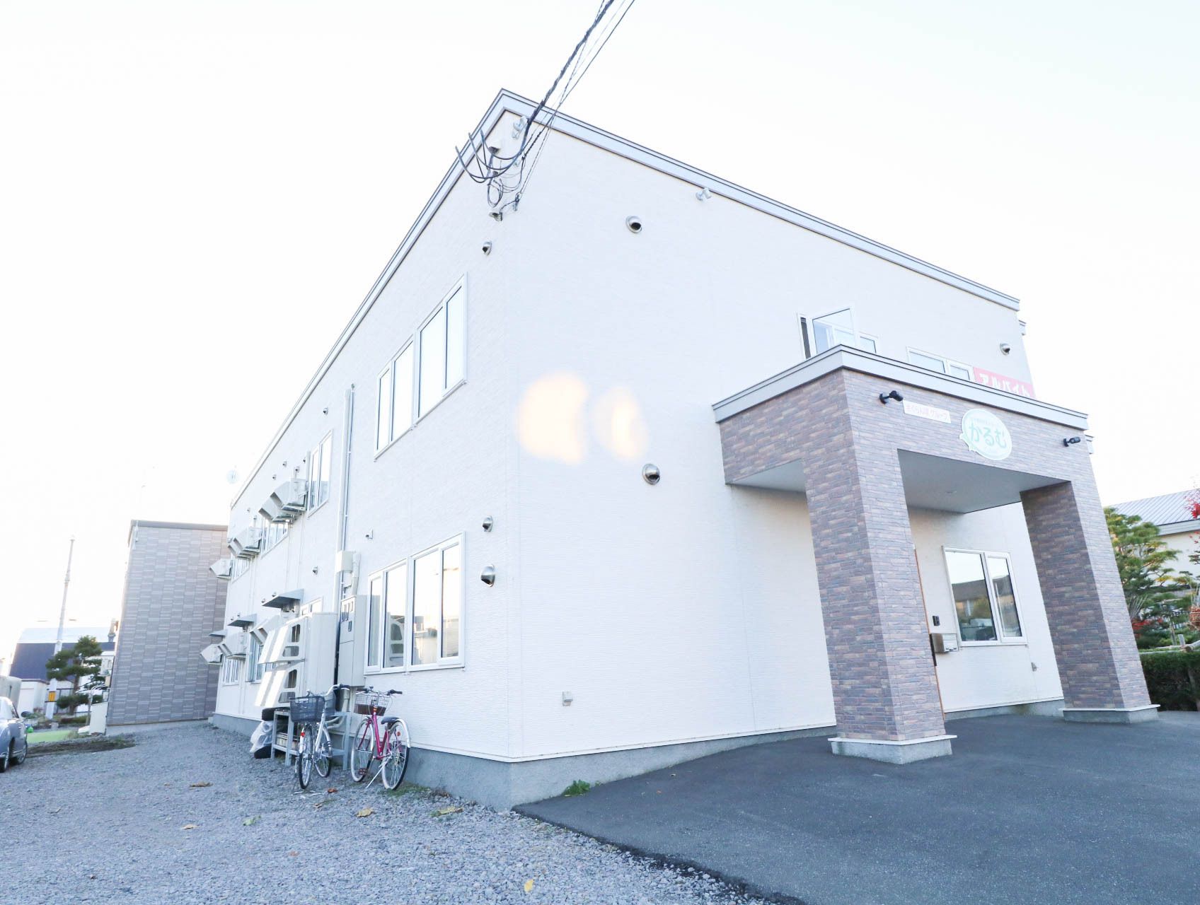 自転車が２台、外に停められている真っ白な外観の建物
