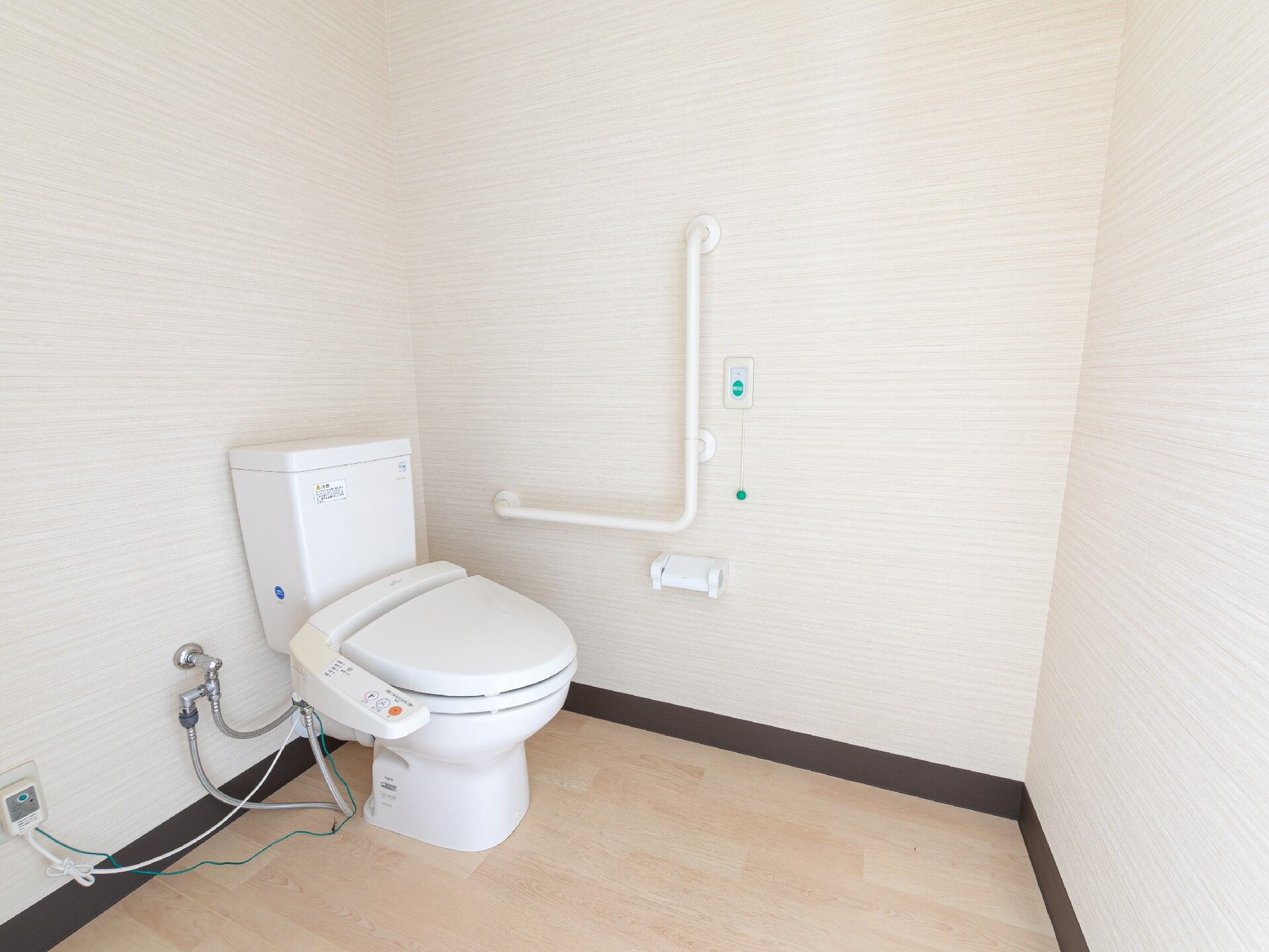 白い壁で清潔感のあるトイレである。出入り口の扉はスライド式になっており、安全に開閉することができる。