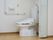 アコーディオンカーテンをあけるとトイレがある。白い便座で、壁にはＬ字型のてすりがついている。呼び出しボタンもある。