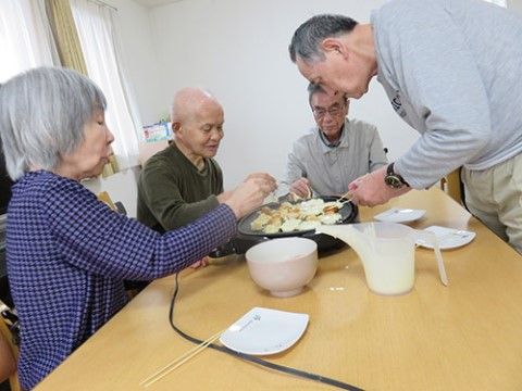 丸いホットプレートでたこ焼き作りを楽しんでいる４人の入居者様