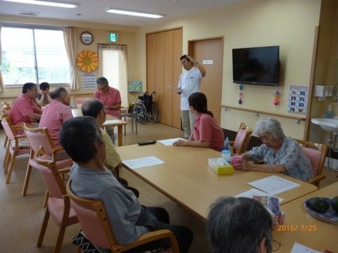 細長いリビングルームは、入居者様の共有スペースであり、スタッフも座学などで用いる場所である。非常口として用いる出入り口がある。