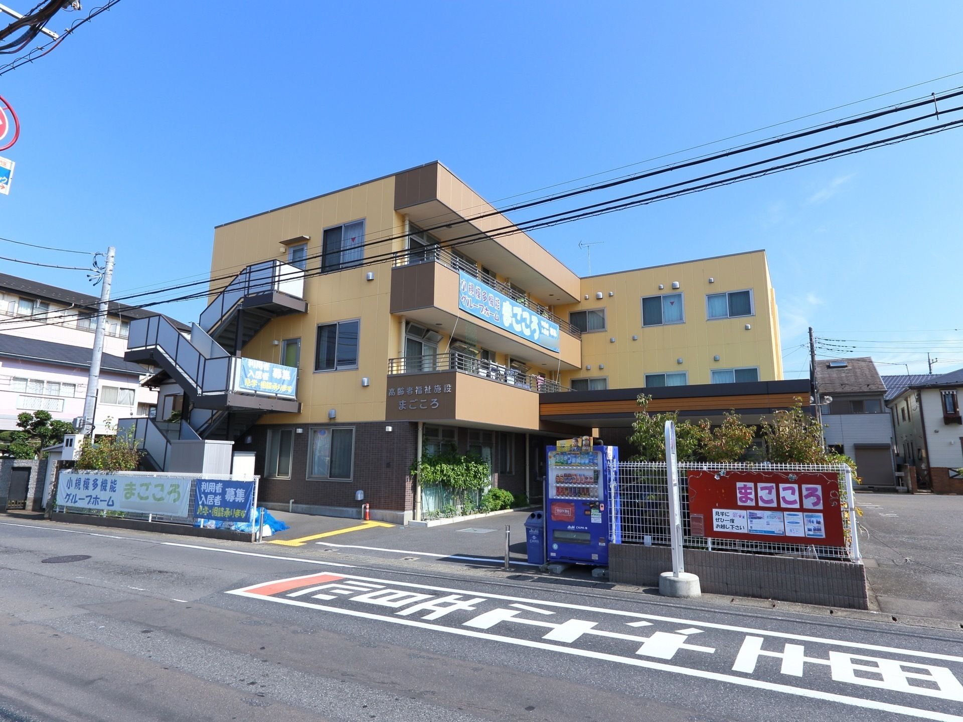 入口はくの字に曲がった位置にある。１階に大きな屋根が付いており、雨の日にも問題なく出入りできる構造。
