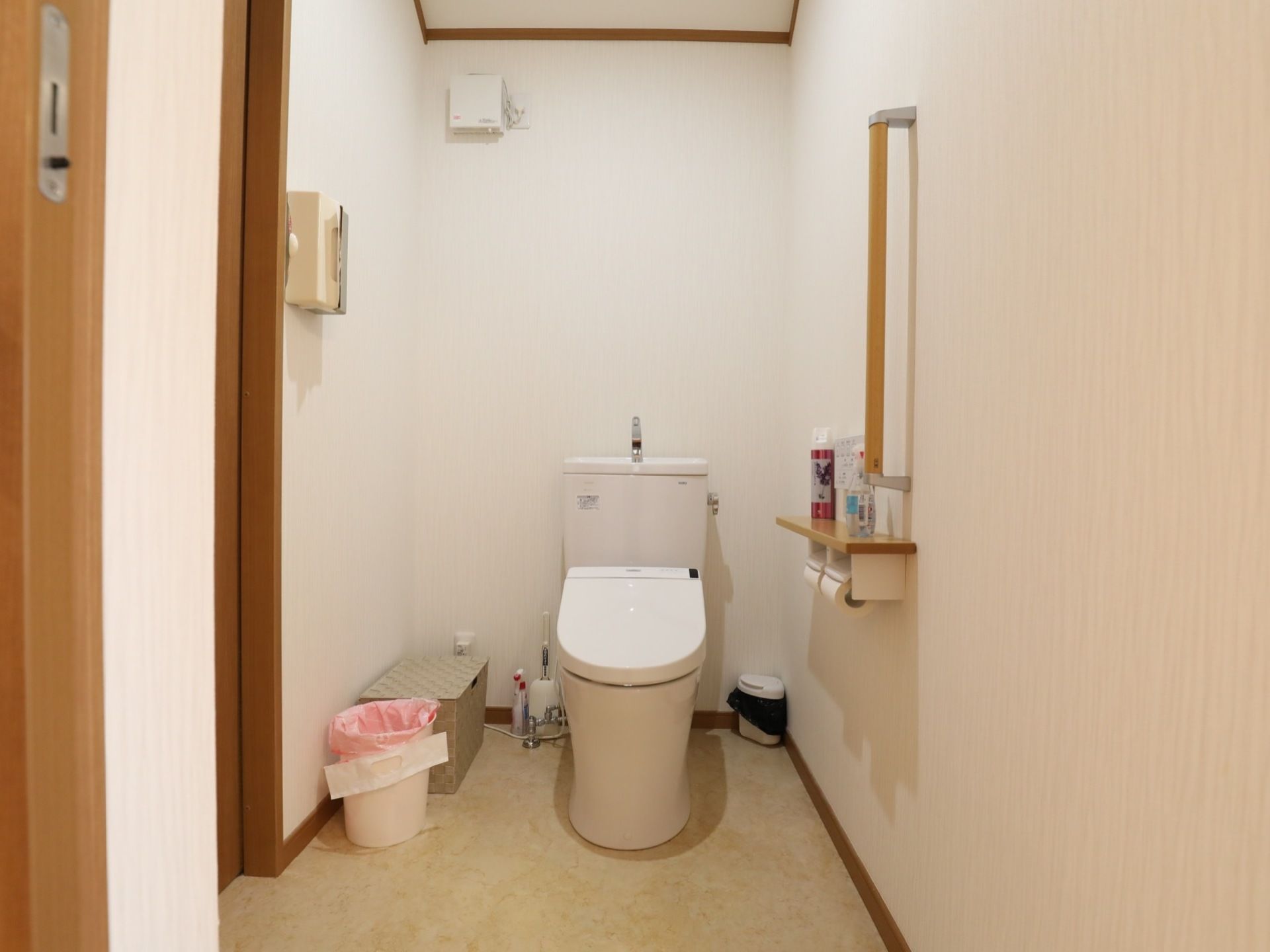 温水洗浄機能付きの洋式トイレである。トイレットペーパーホルダーの台の上には、消臭スプレーが置かれている。