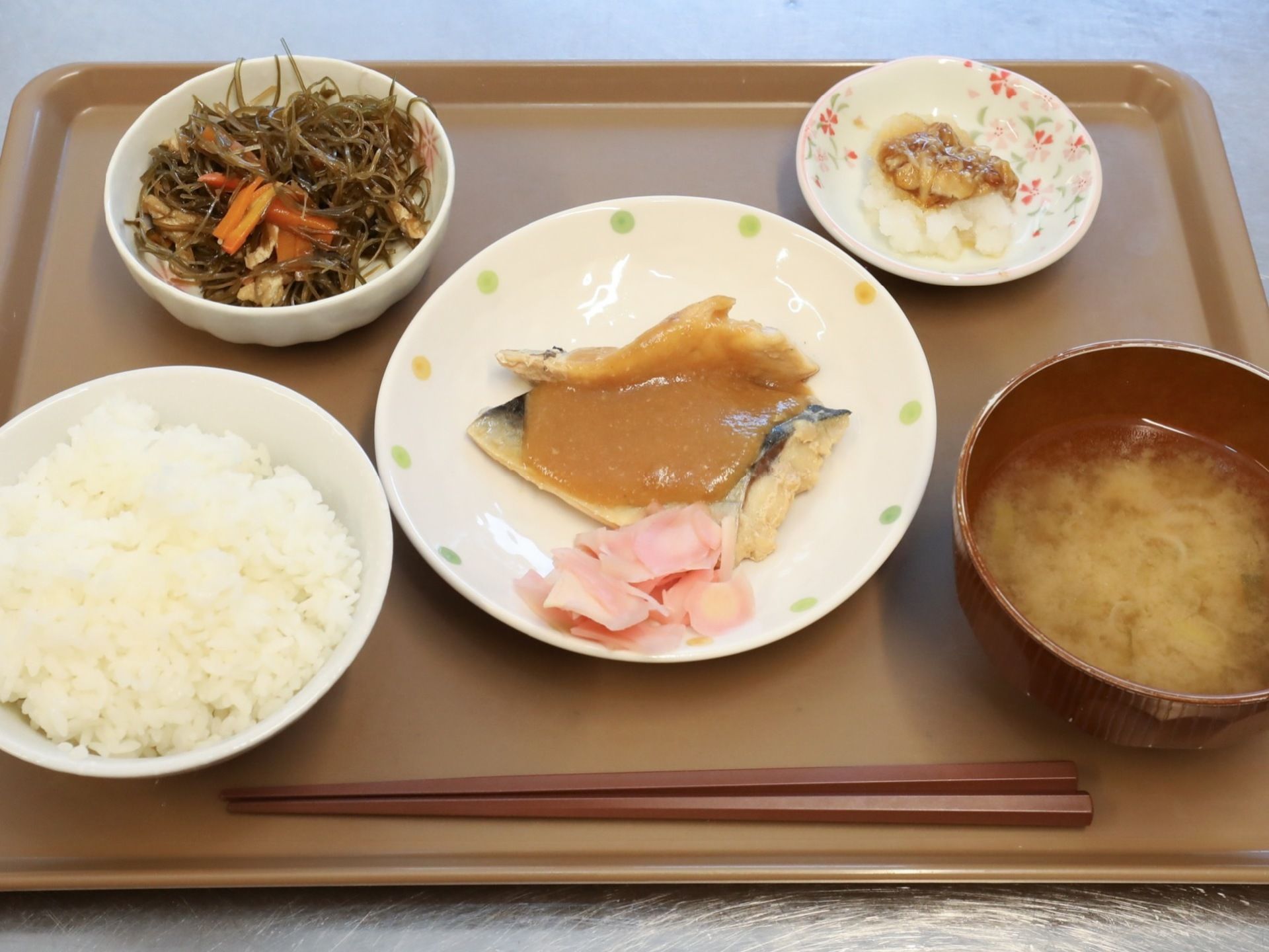 トレーの上にお食事が乗せられている。ご飯と汁物の他に、メインのお魚料理とおかずが２品並べられている。