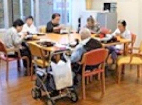 赤や黄色の椅子に座って、食事をたのしんでいる入居者様達