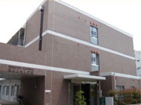 ブラウンを基調とした建物である。玄関には雨除け、日除け用の屋根が付いている。施設周りには観葉植物を配置している。