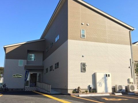 ベージュ色と茶色の２色の建物である。入口前にはスロープが設けられており、車椅子をご利用の方にも安全な構造である。