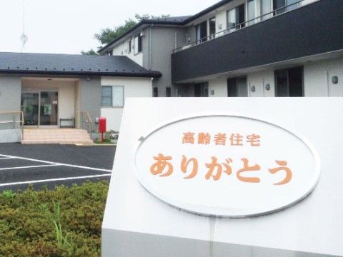 施設は木造２階建ての建物である。エントランスには、手すりを備えたスロープと階段が設けられている。駐車場が建物前にある。
