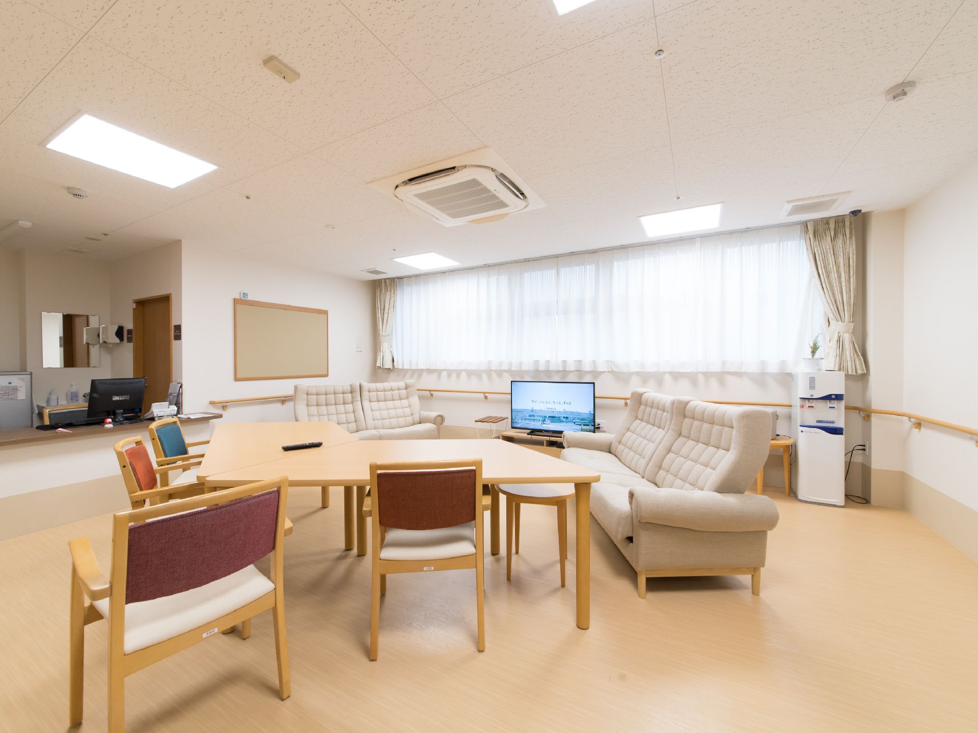 テレビに向かって大きなソファや、テーブルセットが並ぶダイニング