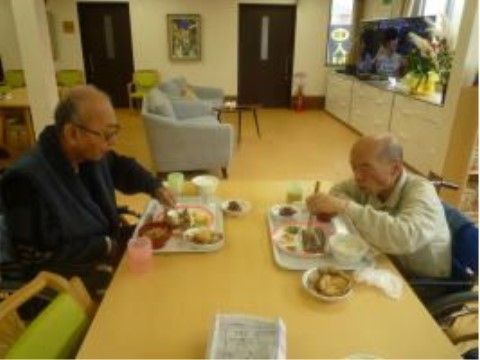 ダイニングテーブルで食事を楽しんでいる男性の入居者様