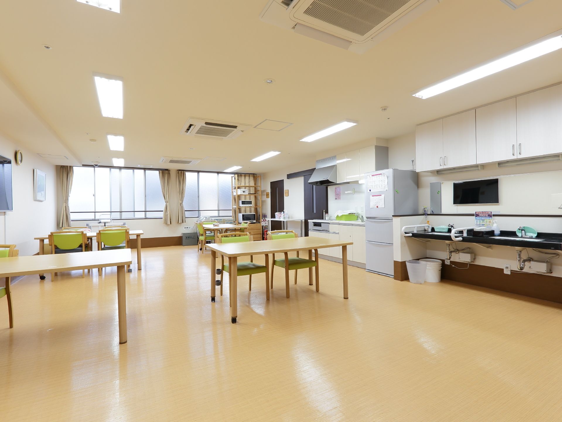 ダイニングルームには、手すりがついた洗面台を用意している。また入居者様がくつろげるように、壁には大型テレビ設置している。