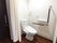 居室のトイレには洋式の温水洗浄便座を設置している。また壁には緊急時の呼び出しボタンがあり、手すりが取り付けられている。