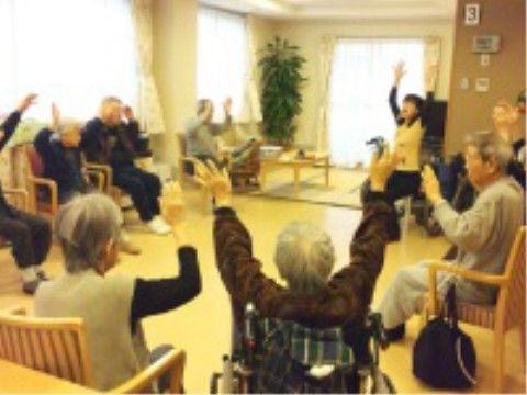 円形に椅子が並べられた広間に集まって、スタッフと一緒に体操をする入居者様