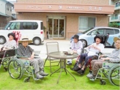 敷地内にある芝生の庭でティータイムを楽しむ女性入居者様
