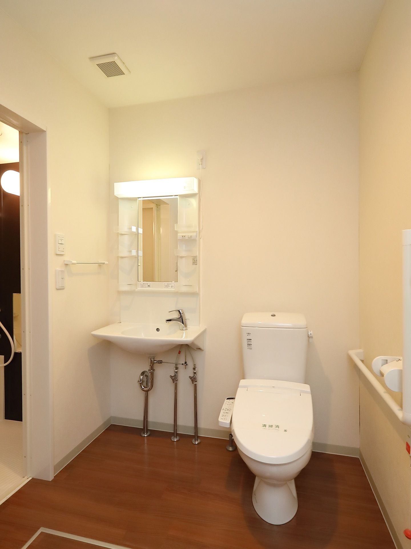 トイレと洗面台を一か所に集約することで、部屋をより広く利用できるように設計されている。天井が高く開放的なデザイン。