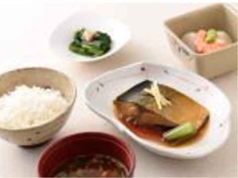 お魚の煮物や小鉢の惣菜が付いたお食事。