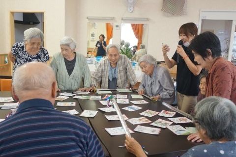 並べられたダイニングテーブルに広げられたかるたを楽しむ入居者様
