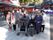 ある神社で撮影した、集合写真。10人ほどの入居者様たちが、写真に写っている。周囲に神社の建物がある。