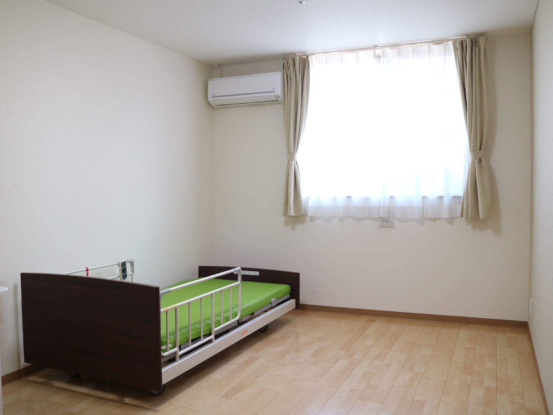 転落防止の柵がある介護用ベッドが置かれている部屋の一例