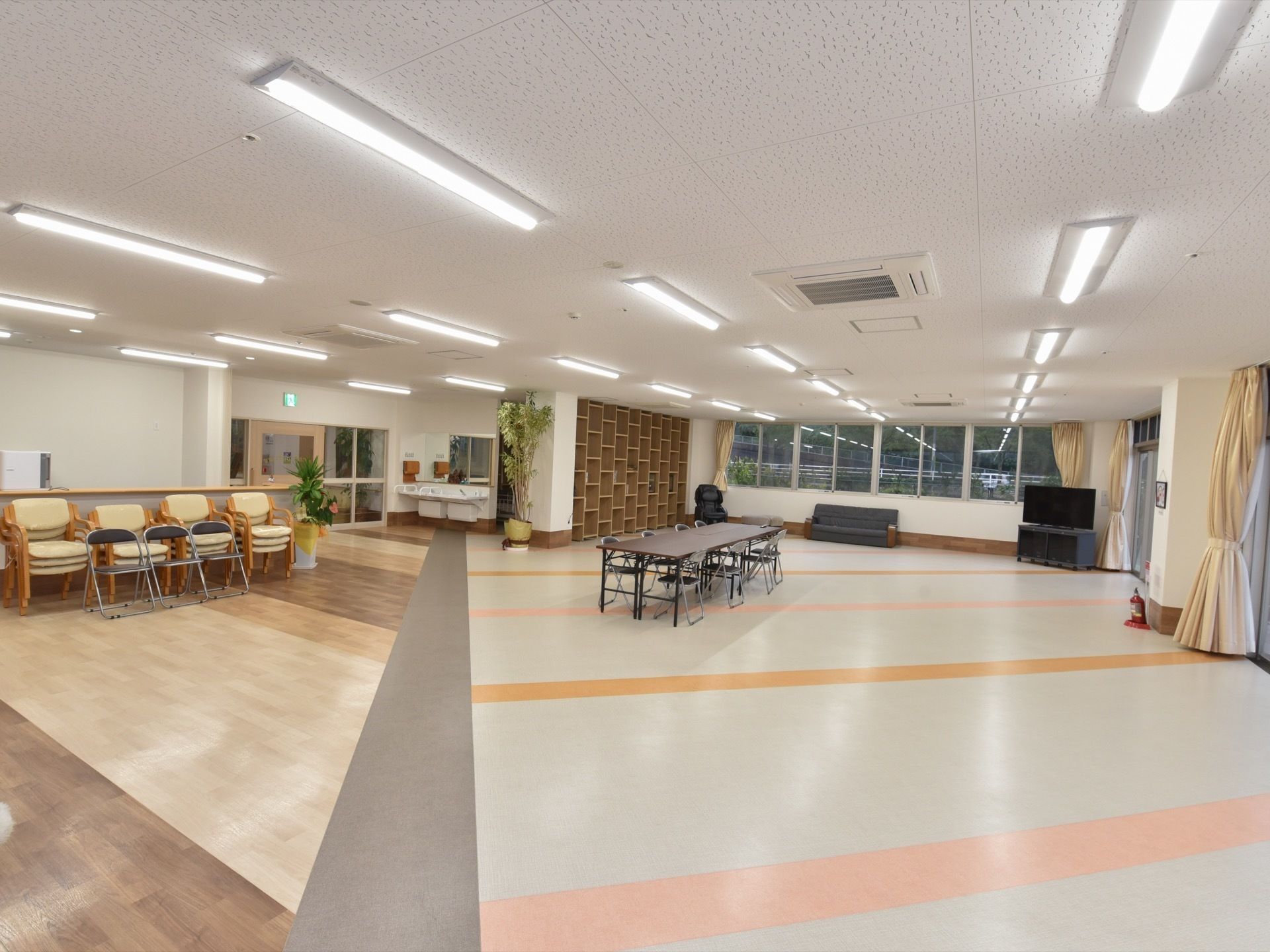 広い空間にテーブルと椅子、ソファ、テレビ、本棚、洗面台が備わっている。たくさん設けられた窓からは、外の景色を眺めることができる。