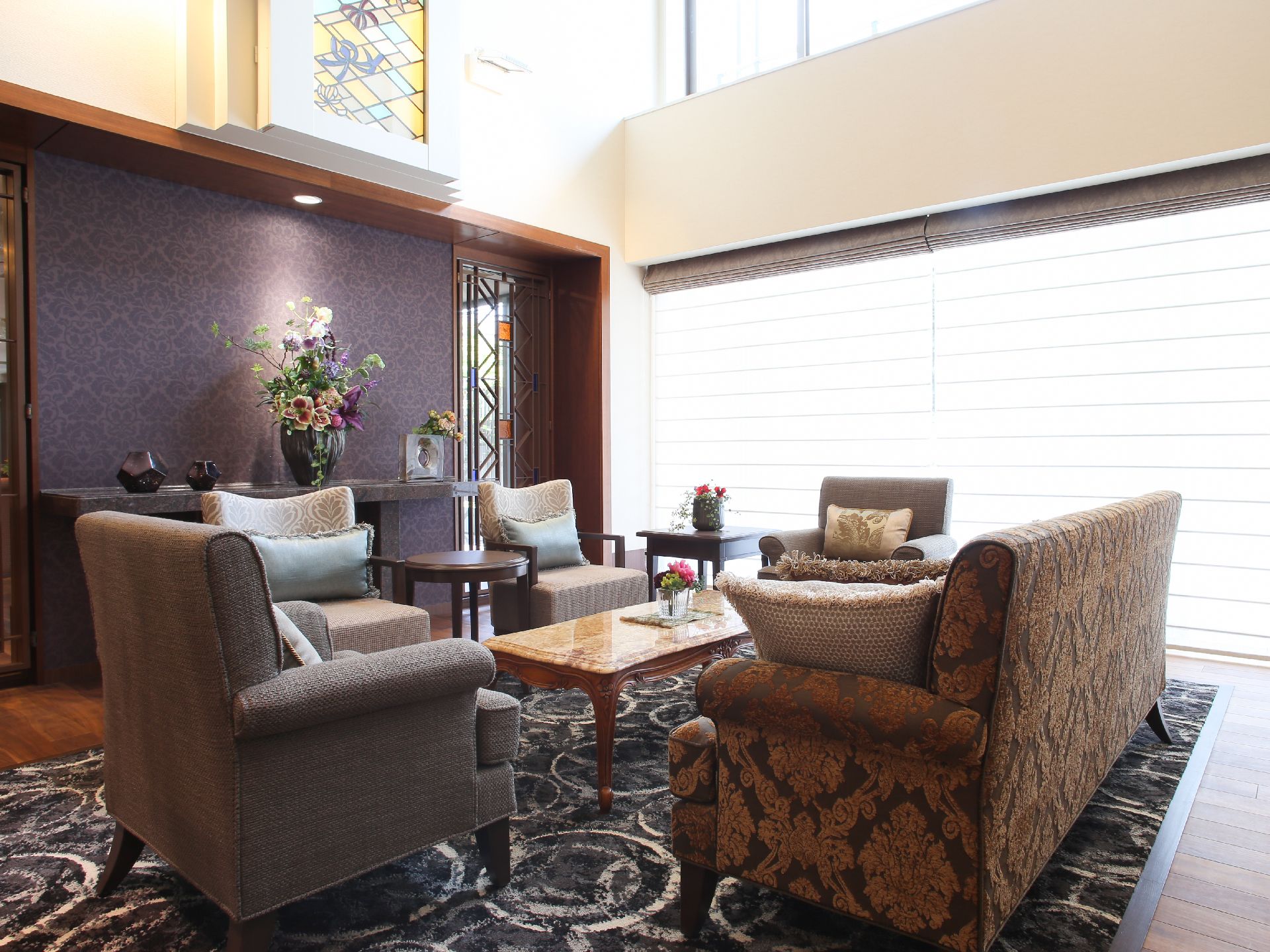 吹き抜けになっており、開放感を味わいながら過ごすことができる。カーペットの上にテーブルとソファが置かれている。