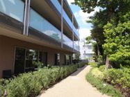 マンションのような外観の施設の外には緑のある空間がある。緑を楽しみながら安全に散歩を楽しめる空間になっている。