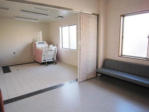 引き戸で仕切られた介護用浴槽のある洗い場と、ベンチが置かれた脱衣所