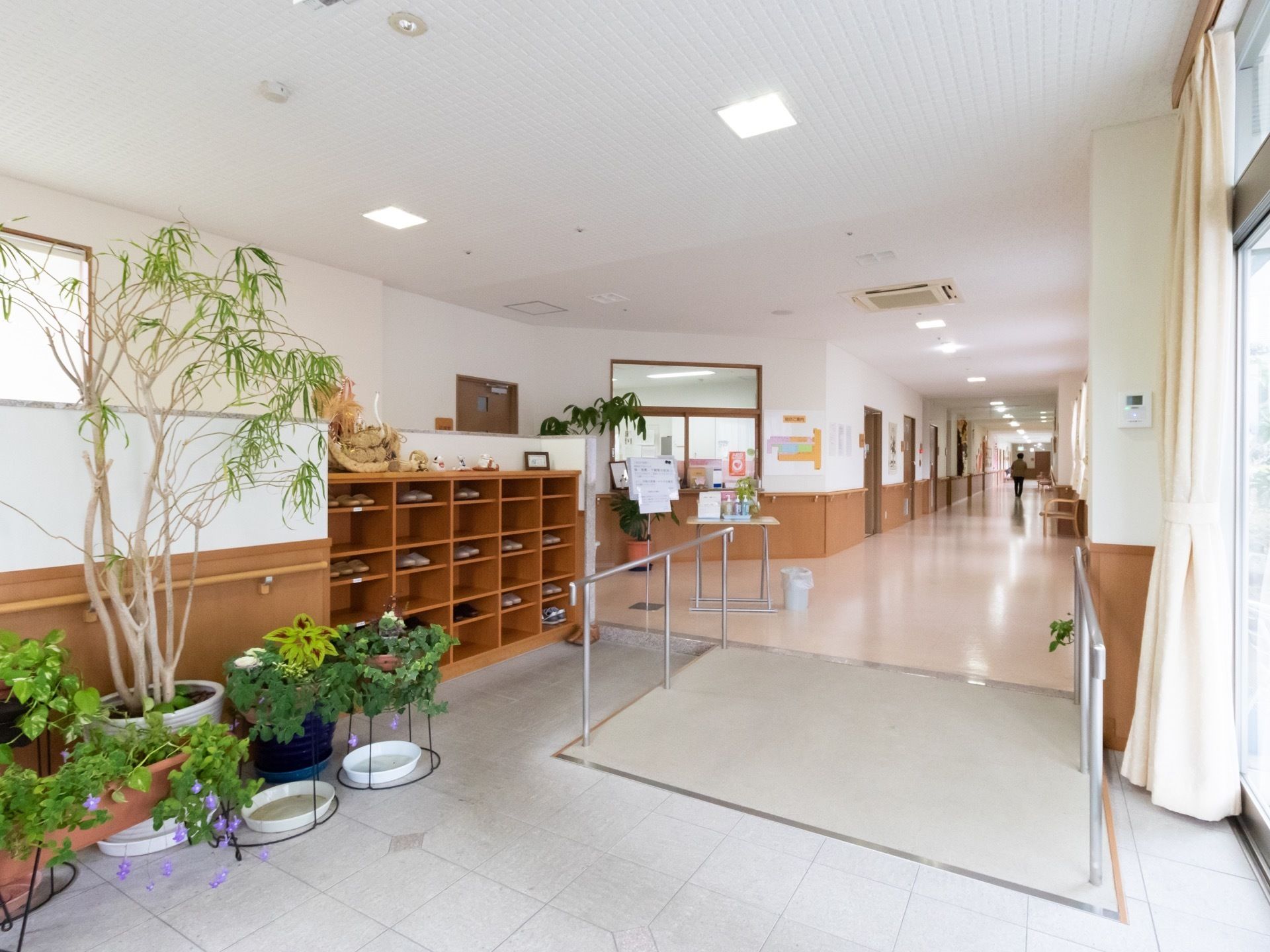 玄関は広々としており、明るい空間である。手すり付きのスロープが設置されており、安全につかまりながら移動することができる。