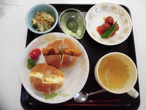 サラダとスープが付いた、たまごサンドとコロッケサンドのセット。