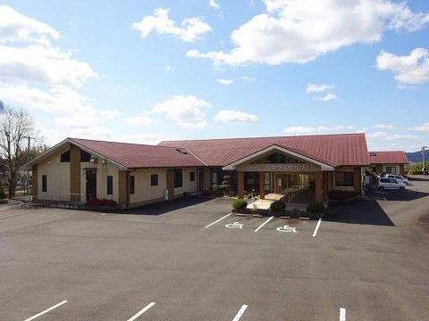 赤い三角の屋根が乗った施設の手前に広がる、とても広い駐車場