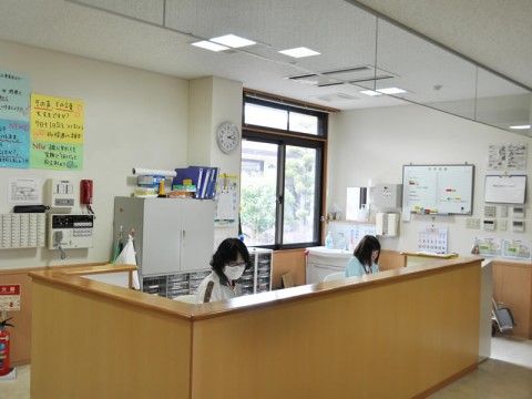 木製のカウンターの奥で事務作業をしている２人の女性スタッフ
