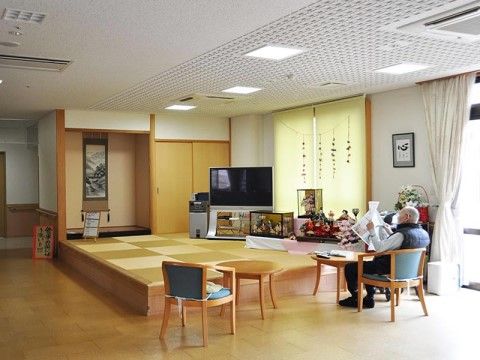 掛け軸や日本人形が飾られた和室の小上りがあるリラックススペース。ちょっと腰を掛けるのに丁度良い高さになっている。