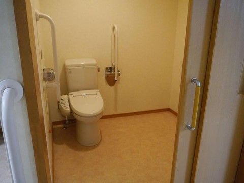引き戸になっているトイレは、車椅子をご利用の方にも気軽にお使いいただけるような広さがあり各所に手すりも完備されている。