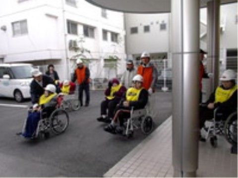 車椅子に乗った入居者様のサポートの練習をしているスタッフ