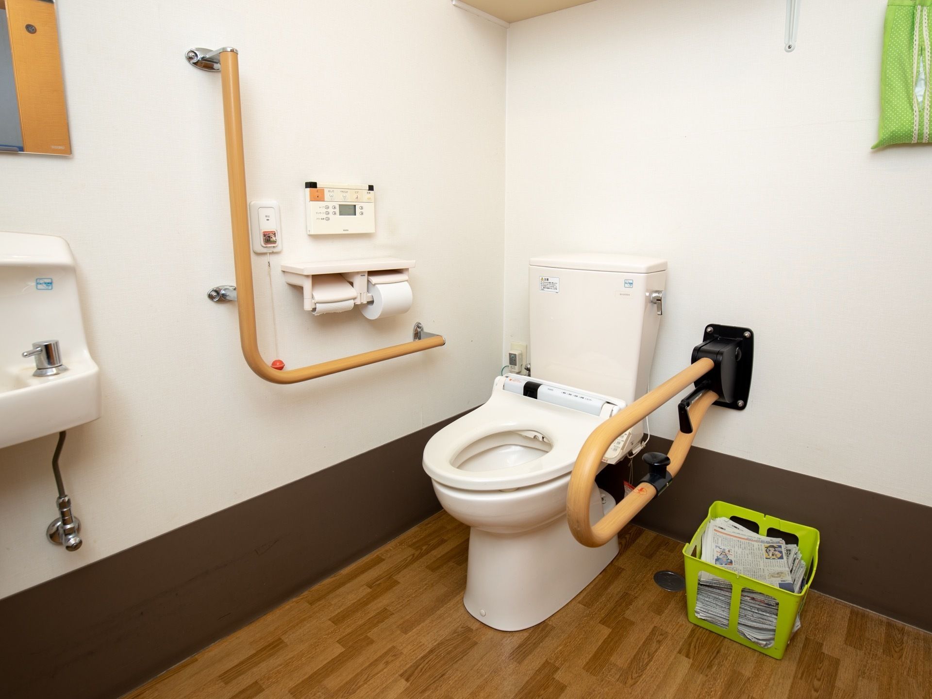 白とブラウンで統一された新しいトイレである。ナースコールや手すり、手洗いスペース、新聞紙が完備されている。