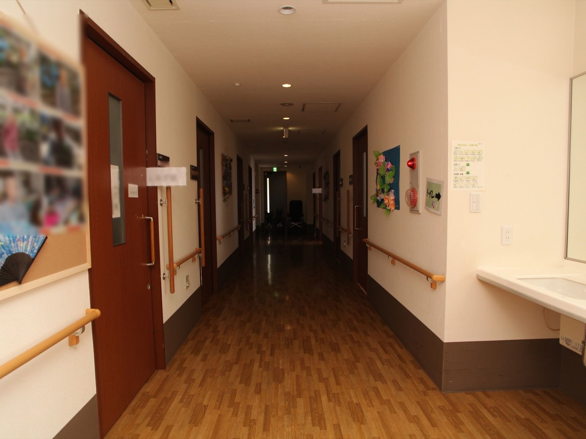 広々とした通路の両側には、手すりが備え付けられている。壁には掲示物や、火災報知器のベルなどが設置されている。