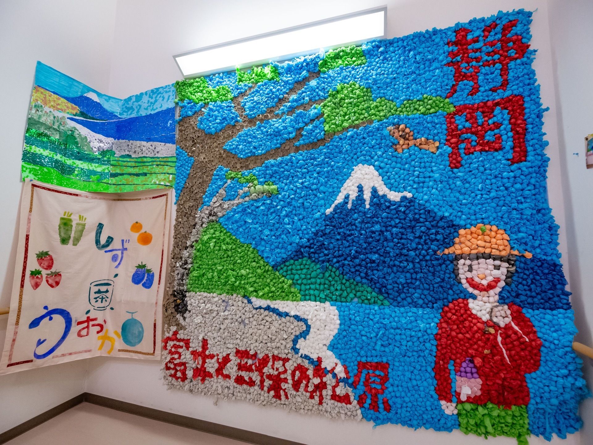 壁一面に大きな貼り絵が飾られている。世界遺産の景色を表した風景画になっている。貼り絵の横には水彩画も貼られている。