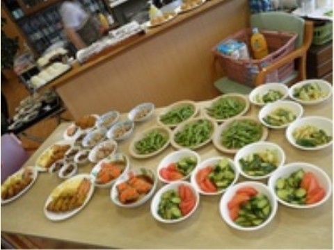 食事の準備が続くテーブルに並べられたサラダや揚げ物