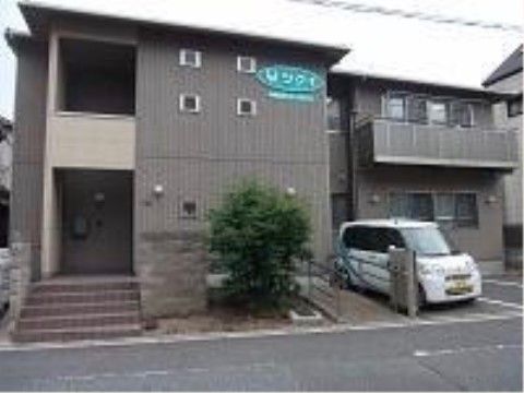 屋根の下に白い字で施設名が書かれた緑の看板がある外観
