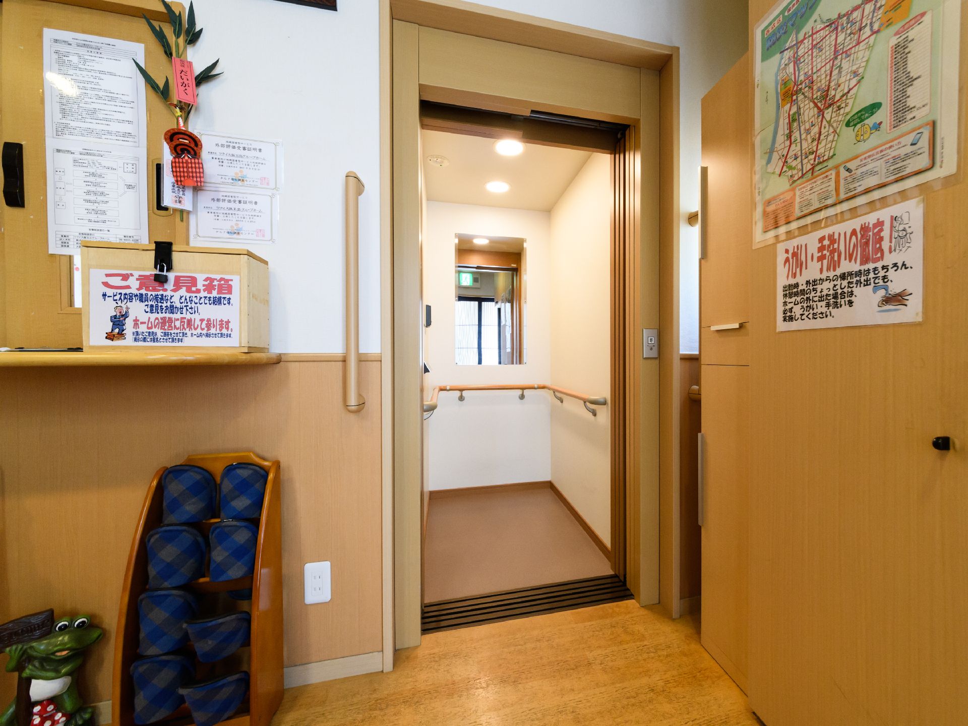 室内にはエレベーターが設けられている。エレベーターの中にはバリアフリーの手すりが設けられている。奥には鏡がついている。