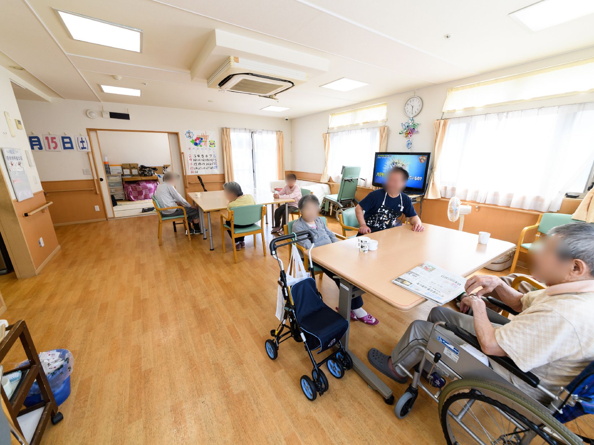 窓からは陽が差し込み、とても明るい。空調が天井に付いている。壁にはカレンダーが掛かっている。和室が隣接している。