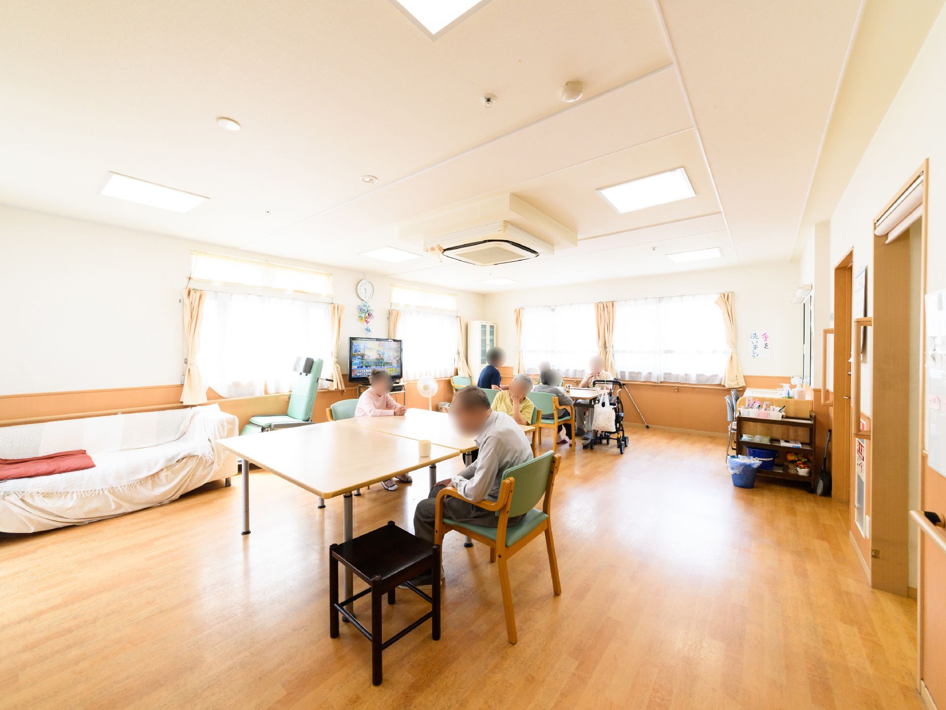 広々とした空間に、複数のテーブルや椅子が置かれている。車椅子でも移動しやすいように、ゆとりをもった配置になっている。