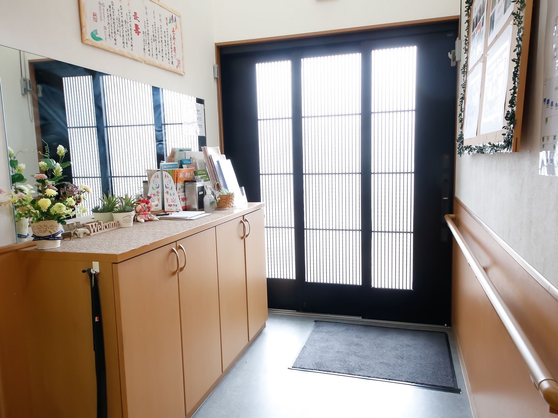 幅が広くとられている引き戸の玄関。ガラス張りなので光が入りとても明るい印象を受ける。鏡を設置してあるので広く見えるよう工夫がされている。