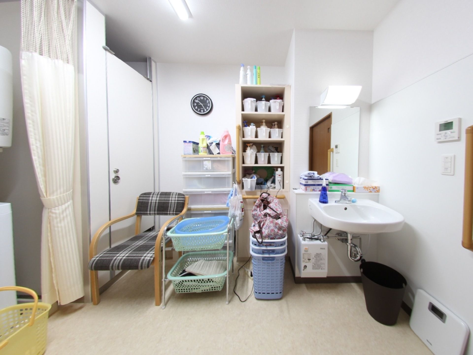 脱衣所は収納棚や椅子などの家具を壁に寄せて配置して、真ん中を通路として広く空けている。車椅子をご利用の方も移動がしやすい配置。