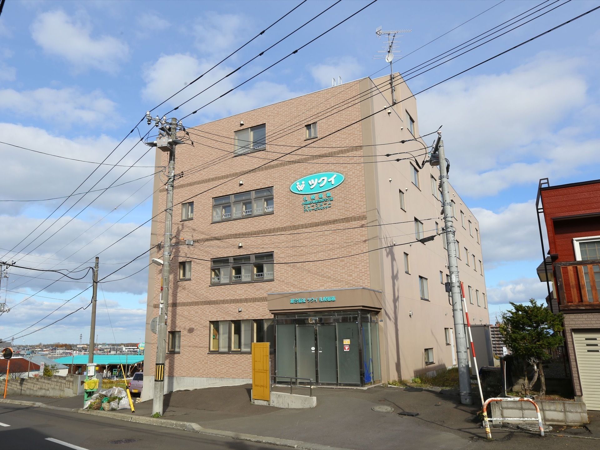施設の建物は、玄関がガラス張りになっており、４階建てでビルのような外観をしている。周囲には高い建物がないので、各窓には日が当たっている。