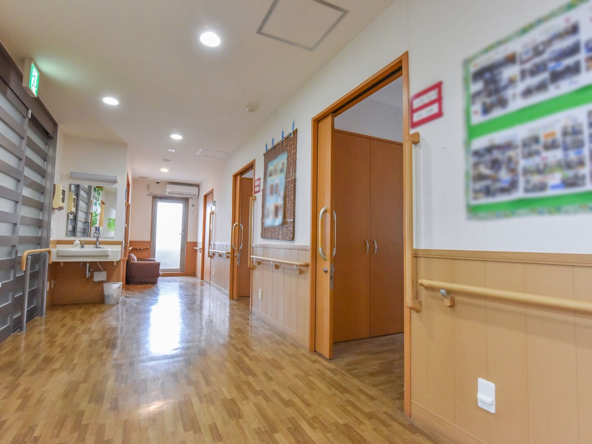 居室前の廊下は広々としたスペースがあり、洗面台やソファが設置されている。壁には手すりが取り付けられている。