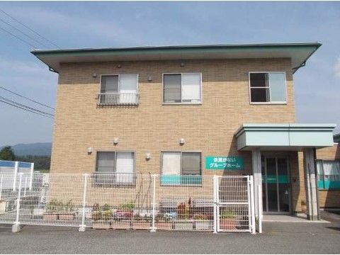 アパートのような２階建ての建物である。敷地内にプランターがいくつも置かれている。フェンスも設置されている。
