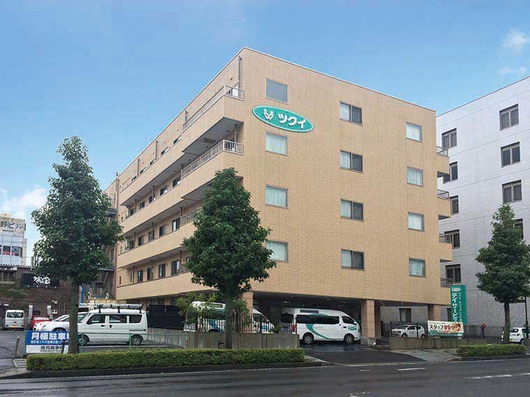 大通に面しており、低い植え込みで囲まれたオレンジ色の建物