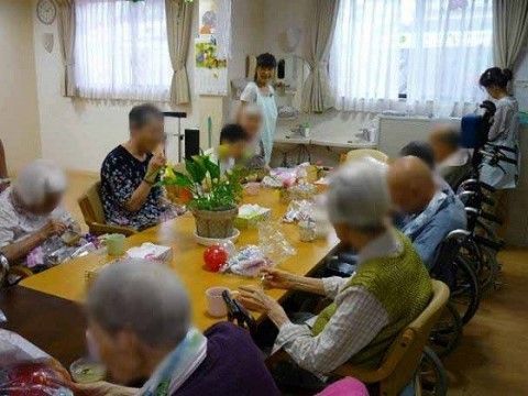 ご入居者様同士で談笑し、２人のスタッフがサポートをしている部屋