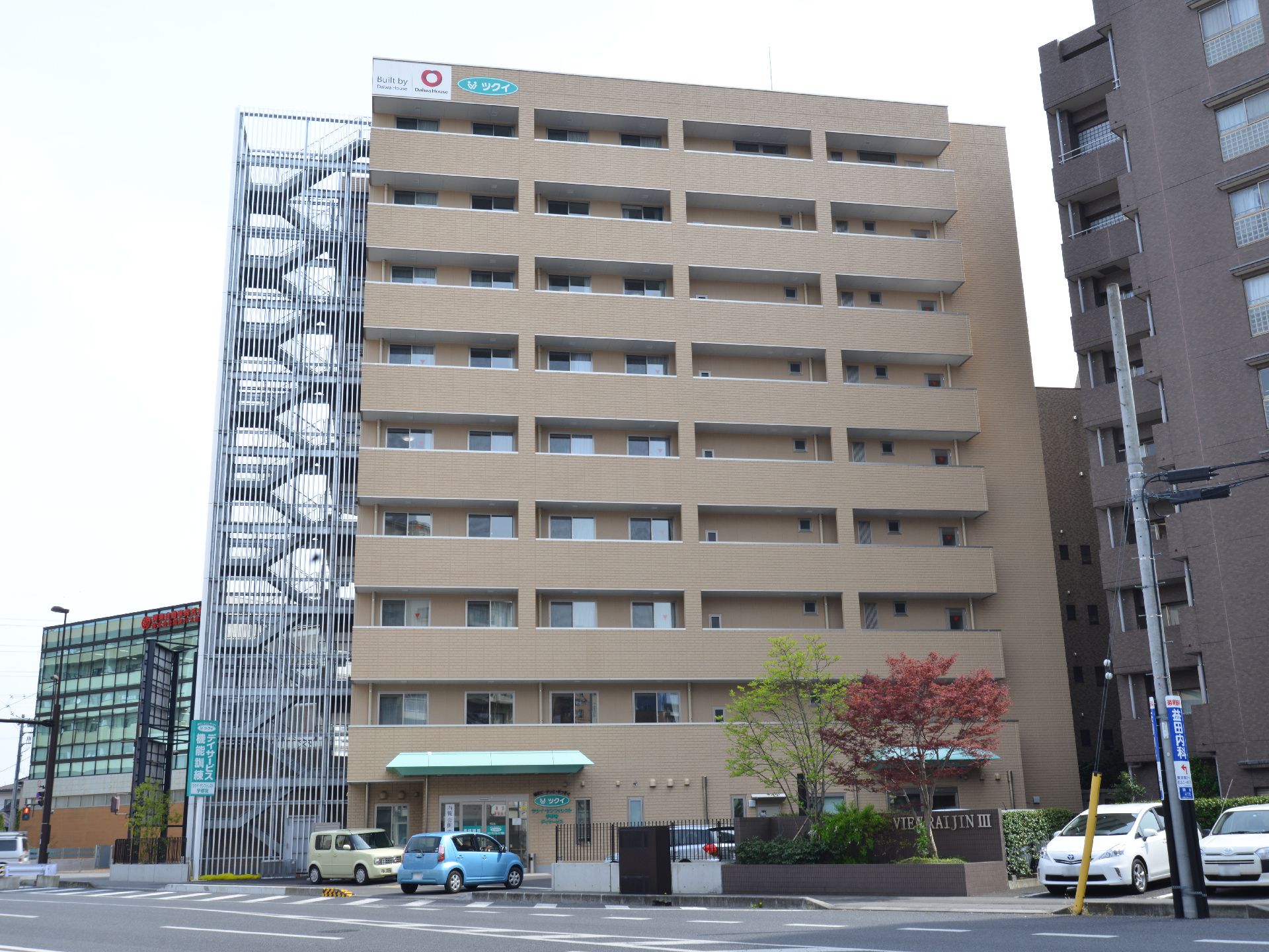 鉄製の外階段が建物の左側にある、９階建ての施設外観